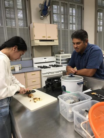 Mr. Cabrera watching Isabella Eugenio cut potatoes