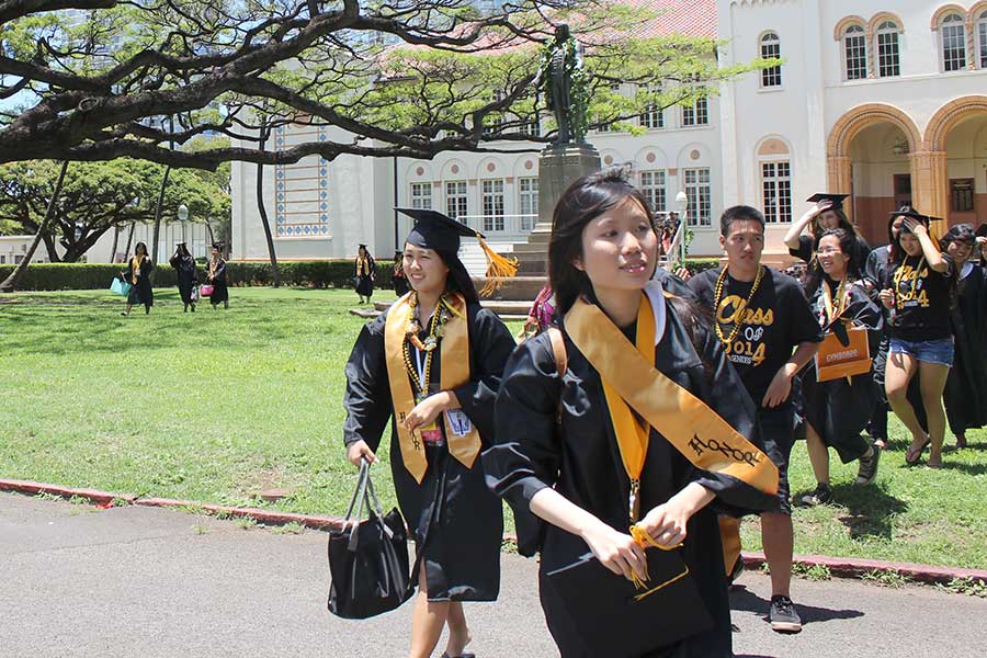 Graduates cross oval after rain delay
