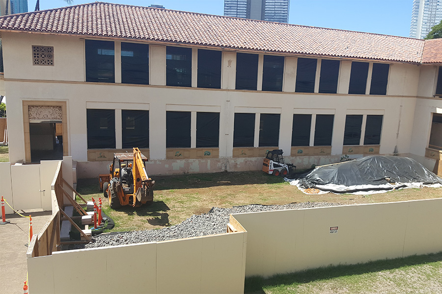 Tall white walls are placed around the left half of W Building to keep students out. 