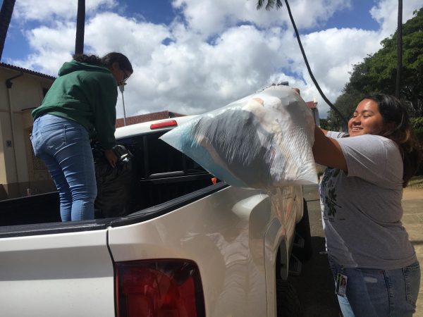 Students Michel Libokmeto and Jessica Cristina Valdez (both c/o 2024) load up trucks with the donations made by the McKinley community. Photo by Shane Kaneshiro 