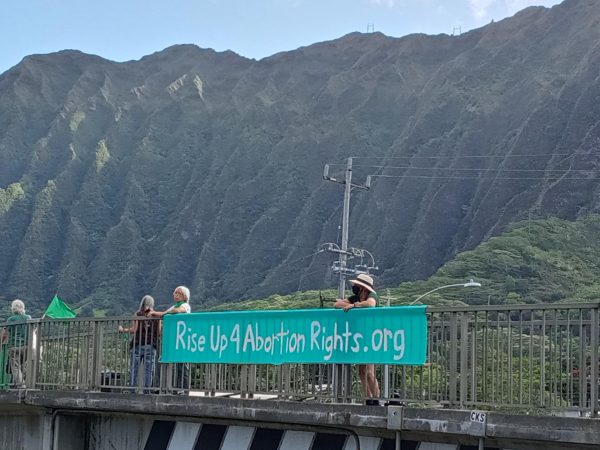 Refuse Fascism group members participate in a sign-holding over the highway entering Kaneohe in June of 2023. Photo by Malia Manuel. 