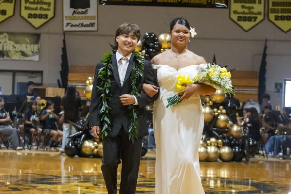 Homecoming King Brayden Kaneko and Homecoming Queen Angriel Olap walk through the Saber Guards' Sword Arch.
Photo by Dominic Niyo