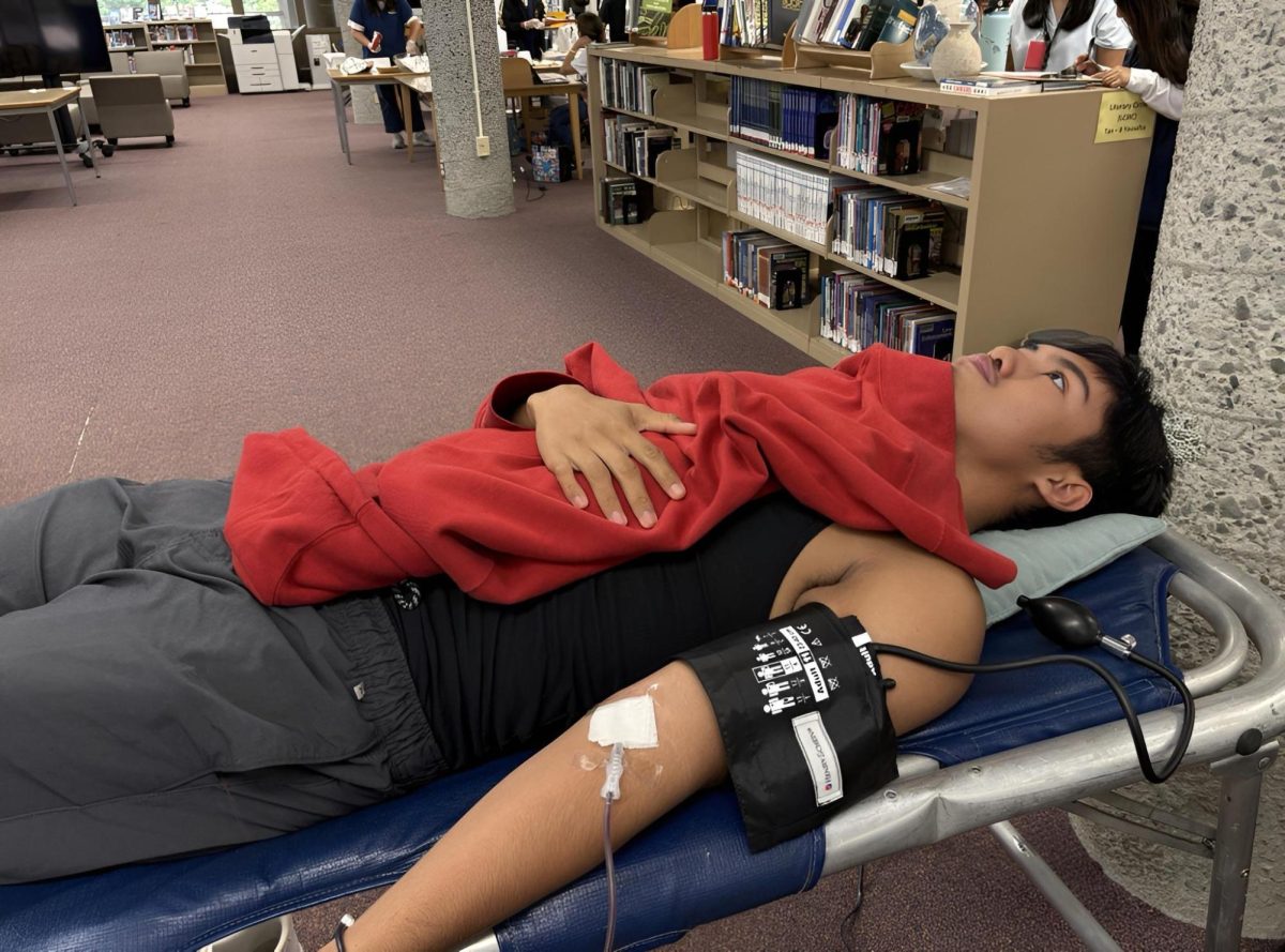 Motivated by the desire to support local hospitals and patients in need, first-time donor Julius Baja (c/o 2026), donates blood at McKinley High School's blood drive event.