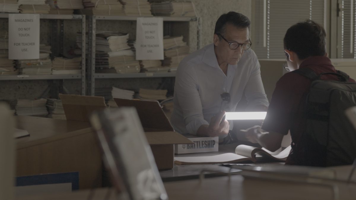 McKinley alumnus Shane Kaneshiro shows David Ono The Pinion newspapers published during WWII. 