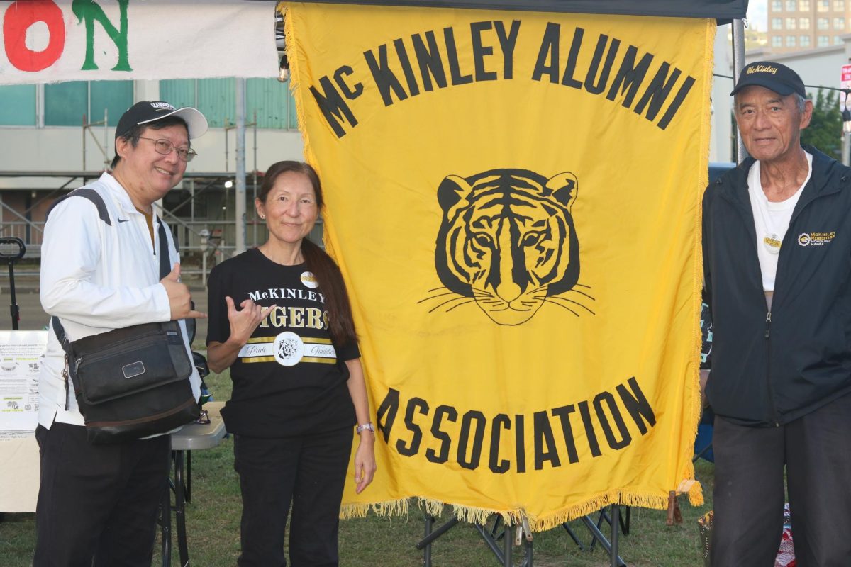 From left, Roland Yee, Barbara Inouye-Young and Bucky Kaopuiki represent the McKinley Alumni Association during McKinley’s Winter Village event.
