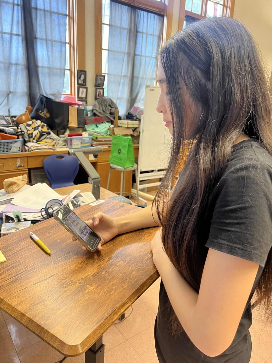 Jasmin Benavente (c/o ‘29) looks at the McKinley athletics sports page as she scrolls through Instagram. Photo by Keilana Yandall (c/o ‘29)