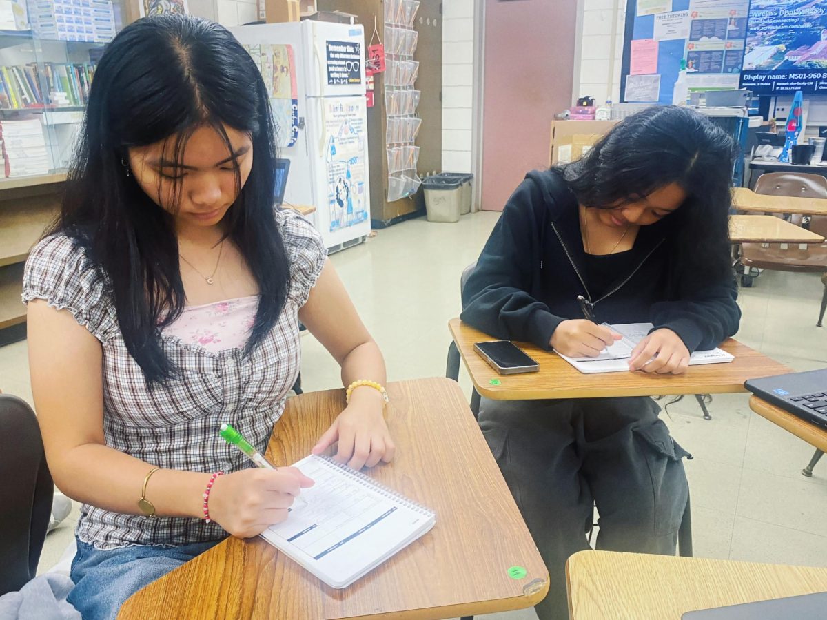 (From Left) Chloe Fabro and Margie Saramosing (both c/o '29) writing in their planners during 20/20.